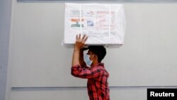 一名工人在达卡搬运印度赠送给孟加拉的牛津-阿斯利康新冠病毒疫苗。(2021年1月21日)