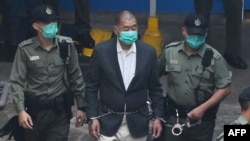 资料照片：香港民主派媒体大亨、《苹果日报》创始人黎智英被带上警车前往法庭，