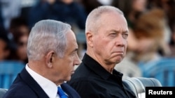 资料照片:以色列总理内塔尼亚胡(左)和国防部长加兰特在以色列一个军事基地出席活动。(2024年10月31日)