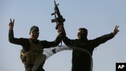 伊拉克特种部队士兵在摩苏尔地区的前线阵地打出胜利的手式。(2016年11月23日)