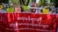 Doctors and health workers hold a banner and signs as they take part in a protest against the military coup in front of the Chinese embassy in Yangon on February 11, 2021. (Photo by Ye Aung THU / AFP)
