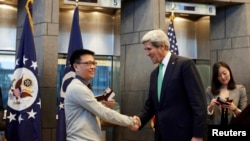 2014年11月12日,美国IBM公司雇员杨波(音译)在美国驻华使馆获得有效期为十年的签证,成为第一获得这样的中国人。图为美国国务卿与杨波握手。