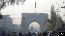 阿富汗人走过坎大哈省省长办公室大门(2017年1月11日)。