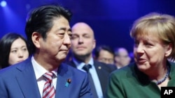 德国总理默克尔和日本首相安倍晋三2017年3月19日出席德国汉诺威CeBIT信息及通讯技术博览会开幕式时交谈。