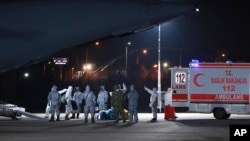 身穿防护服的土耳其医护人员在卡拉奇的一个机场接一架土耳其从武汉撤侨的军机。(2020年2月1日)