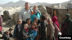 拉米亚阿富汗基金会创始人,退休美国空军中将约翰·布莱德利和妻子简·布莱德利在阿富汗与当地孩子们在一起。(照片由拉米亚阿富汗基金会提供)