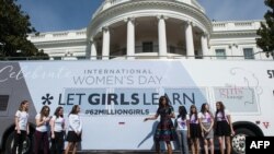 美国第一夫人米歇尔·奥巴马在白宫前与参加“让女孩学习倡议”国际项目的女学生们合影。(2016年3月8日)