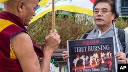 Đại biểu Quốc hội Tây Tạng lưu vong, ông Thubten Wangchen (trái) thực hiện cuộc biểu tình có tên "Ngọn lửa của Chân lý" gần trụ sở Ủy hội châu Âu ở Brussels,