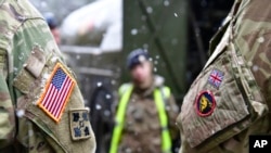 资料照片:在德国布吕克举行的有关“捍卫者-2020“演习的一次记者会后,美英军人并肩站立。(2020年2月26日)