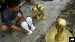 Ông Vương Hồng Nhật bên những chiếc cúp "nhái".