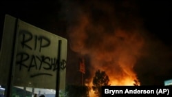 黑人男子雷沙德·布鲁克斯被射杀现场所在的温蒂汉堡快餐店在6月13日的抗议中被烧。牌子上有人喷漆,写上“雷沙德安息”。