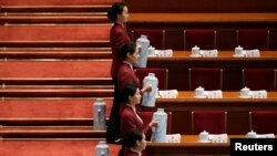Các nữ tiếp viên chờ đợi để rót trà cho các đại biểu tham dự phiên họp Đại hội Đại biểu Nhân dân Toàn quốc tại Đại sảnh đường Nhân dân ở Bắc Kinh, ngày 5/3/2015.