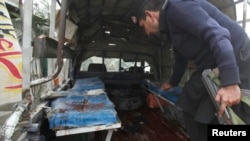 一辆警察的箱型车在白沙瓦郊外的恰尔萨区遭遇炸弹袭击。图为事发后警察在被炸毁的车内搜集证据。(2014年1月22日)