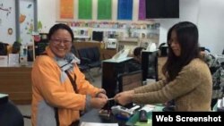 Bà Sơ Mỹ Linh (trái) hoàn tất việc chuyển hộ khẩu ở Cao Hùng, ngày 21/1/2016 (Ảnh chụp từ trang CNA).