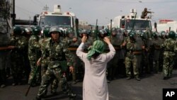 此为乌鲁木齐七五事件后,一名维吾尔族妇女在中国西部新疆地区向一群武警抗议。 (资料图:美联社)