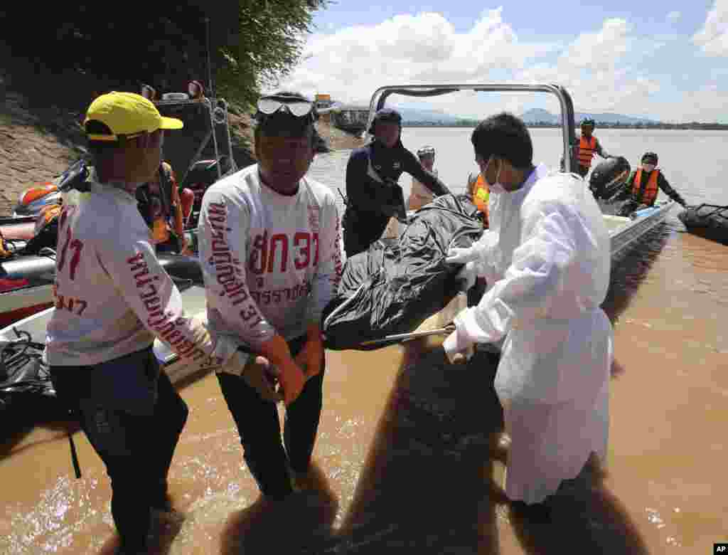 Nhân viên cứu hộ Thái Lan khiêng thi thể một nạn nhân vụ tai nạn máy bay tại thị trấn Pakse, Lào, ngày 18/10/2013.