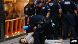 一名女子在纽约川普大厦附近抗议期间被警方逮捕。(2017年8月14日)