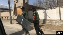 2018年2月17日,警察在中国西部新疆地区和田县的一个村庄巡逻。