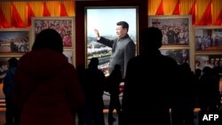 资料图:在北京的中国共产党历史展览馆,参观者从习近平的图片前走过(2021年11月11日)