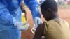 FILE - A Congolese health worker administers Ebola vaccine to a boy who had contact with an Ebola sufferer in the village of Mangina, in North Kivu province of the Democratic Republic of Congo, Aug. 18, 2018.