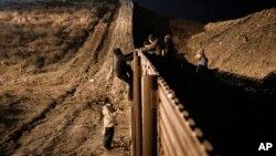 洪都拉斯移民越过边境围栏,试图从墨西哥蒂华纳跳入美国圣地亚哥。(2018年12月25日)
