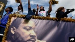 在迈阿密的一处社区举行的“马丁·路德·金日”游行期间,佛罗里达国际大学的花车上的人向观众们挥手。(2017年1月16日)