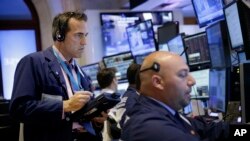 交易员在纽约证券交易所交易大厅内工作。(2015年7月8日,美联社)