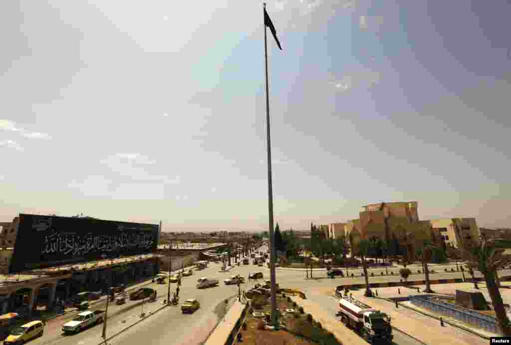 Cờ của nhóm phiến quân Hồi giáo Syria Jabhat al-Nusra tung bay trên quảng trường chính ở Raqqa, ngày 1 tháng 5, 2013.