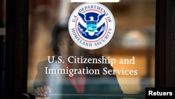 资料照 - 2012年8月15日,一女子离开纽约的美国公民及移民服务局办公室