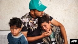 巴勒斯坦儿童在加沙南部的拉法城一座殡仪馆哀悼死于以色列空袭的亲人。(2024年4月27日)