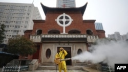 一名工人在武汉汉口教堂救世堂前为防疫新冠病毒喷洒消毒药水。(2020年3月6日)