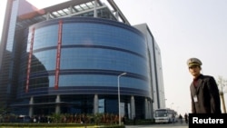 资料照:中芯国际在上海开业时一名保安站在楼前。(2001年11月22日)