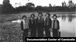 1977年,在这几名微笑着的红色高棉年轻女干部身后,远远地矗立着一座清真寺。