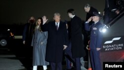 2025年1月18日,美国当选总统唐纳德·特朗普(中)抵达弗吉尼亚州华盛顿杜勒斯国际机场时挥手致意。