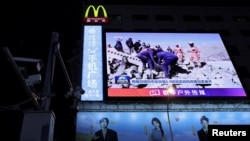 西藏地区日喀则定日县发生地震后,北京街头巨大荧幕上播放着救援人员在搜救行动中的新闻片段。(路透社:2025年1月8日)