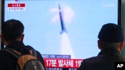 Dân Nam Triều Tiên xem truyền hình về một vụ phóng phi đạn của Bắc Triều Tiên tại một nhà ga xe lửa