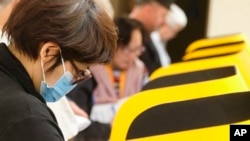 2020年3月3日超级星期二,一位戴口罩的选民在加利福尼亚州蒙特利公园市投票中心投票。