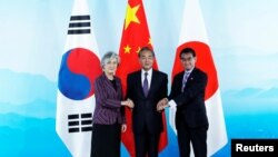 左起:韩国外长康京和、中国外长王毅和日本外相河野太郎在北京举行的中日韩三国外长会议上握手。(2019年8月21日))