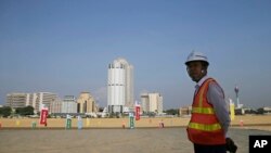 资料照片：一名中国建筑工人站在一带一路工程项目斯里兰卡科伦坡港口城工地上。(2018年1月2日)