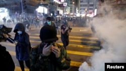 香港圣诞节平安夜举行的抗议活动中反政府示威者逃离警察发射的催泪弹。(2019年12月24日)