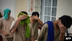 因在津巴布韦住所查获犀牛角被捕的七名中国公民1月3日首次在维多利亚瀑布地方法院出庭。离开法庭时,他们中有人为避开摄像机用毛巾遮盖脸部