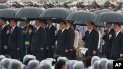 中共总书记习近平、中国总理李克强、中共政治局常委张德江、俞正声、王岐山等人在雨中在人民英雄纪念碑前唱国歌(2013年10月1日)