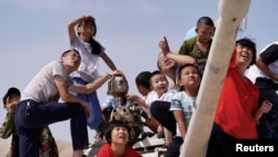 中国新疆库尔勒地区举办的国际军事比赛2018年期间,人们在观看中国军队三场比赛的开幕式。(2018年7月29日)