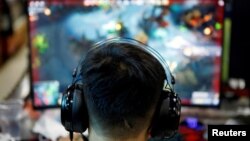 资料照:一名男子在北京的一家网吧玩电游。(2021年8月31日)