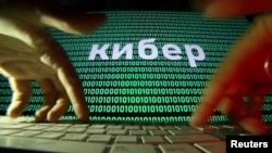 资料照：在电脑键盘上的两只手与屏幕上显示的网络代码 (路透社）