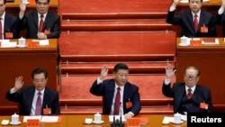 中国共产党第十九次全国代表大会闭幕式上,中共总书记习近平和前总书记江泽民、胡锦涛等人举手表决(2017年10月24日)。