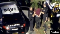 2018年2月14日在佛罗里达州帕克兰拍摄的一段视频中,警察在玛乔丽·斯通曼·道格拉斯高中校园附近逮捕克鲁兹给他戴上手铐。