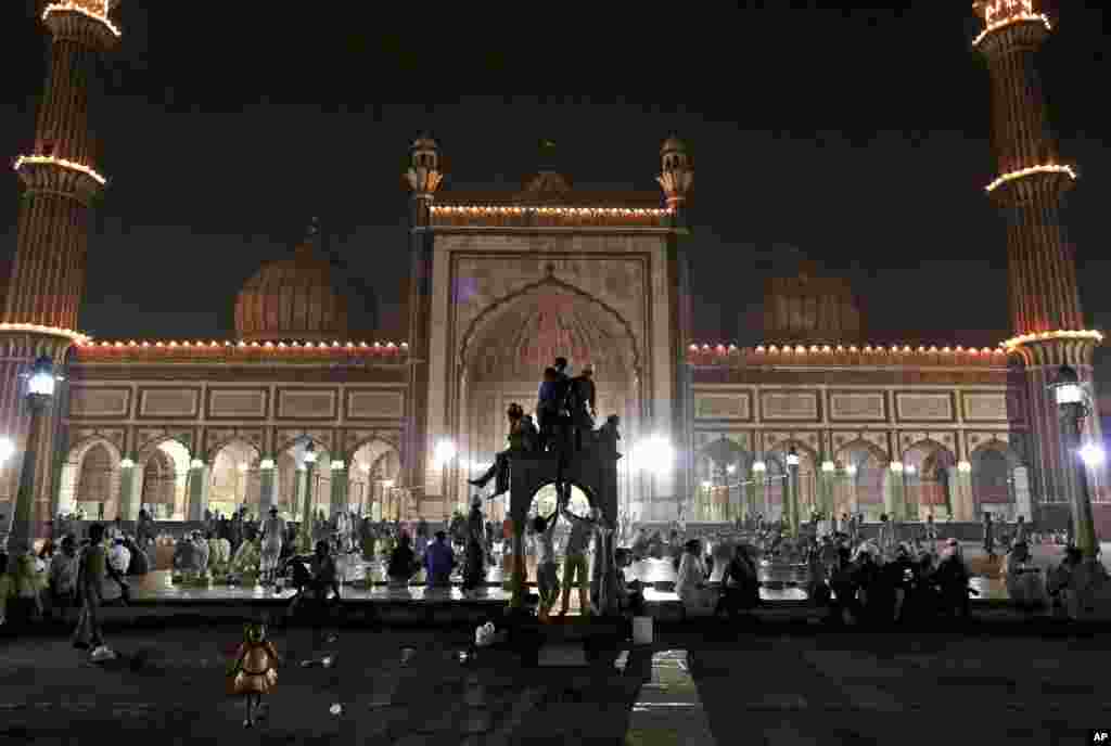 Trẻ em Hồi giáo Ấn Độ leo lên bệ đá vui đùa sau khi dứt tháng chay Ramadan, bắt đầu lễ Eid al-Fitr ở New Dehli.