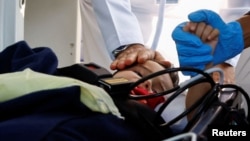 从以色列加沙地区疏散的巴勒斯坦儿童和家庭抵达阿联酋首都阿布扎比接受治疗。图为医护人员在照顾一名受伤的男孩。(2023年11月8日)