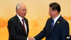 2014年11月11日亚太经合组织(APEC)峰会: 马来西亚总理纳吉布(左)与中国国家主席习近平握手